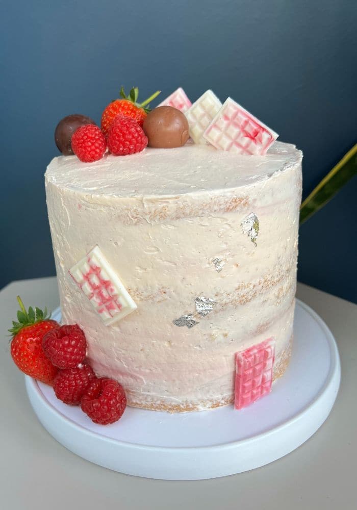 Semi-naked cake with fresh strawberries, raspberries and pink chocolate