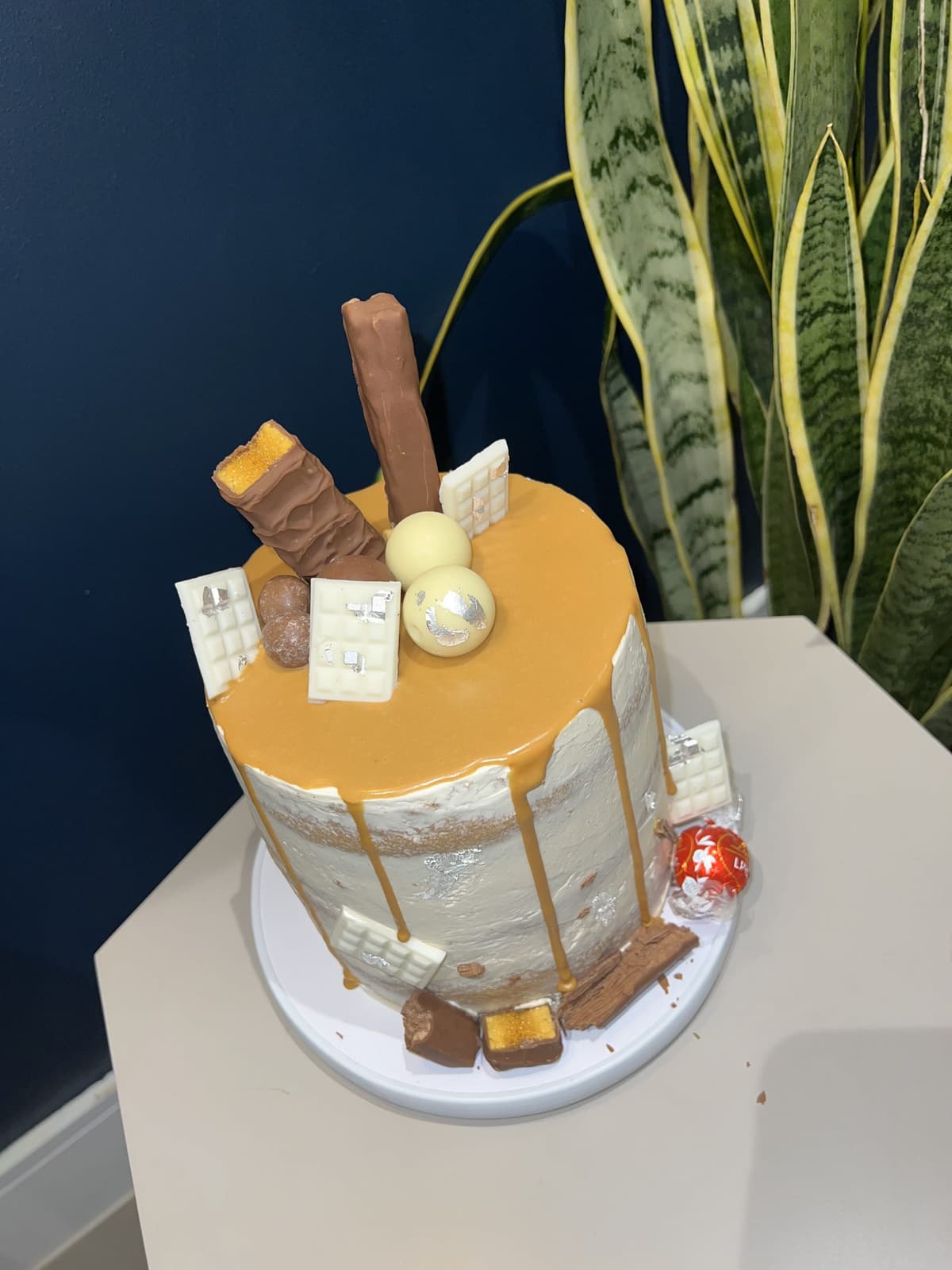 Cake with a smooth caramel glazed top and chocolate bars around the edge