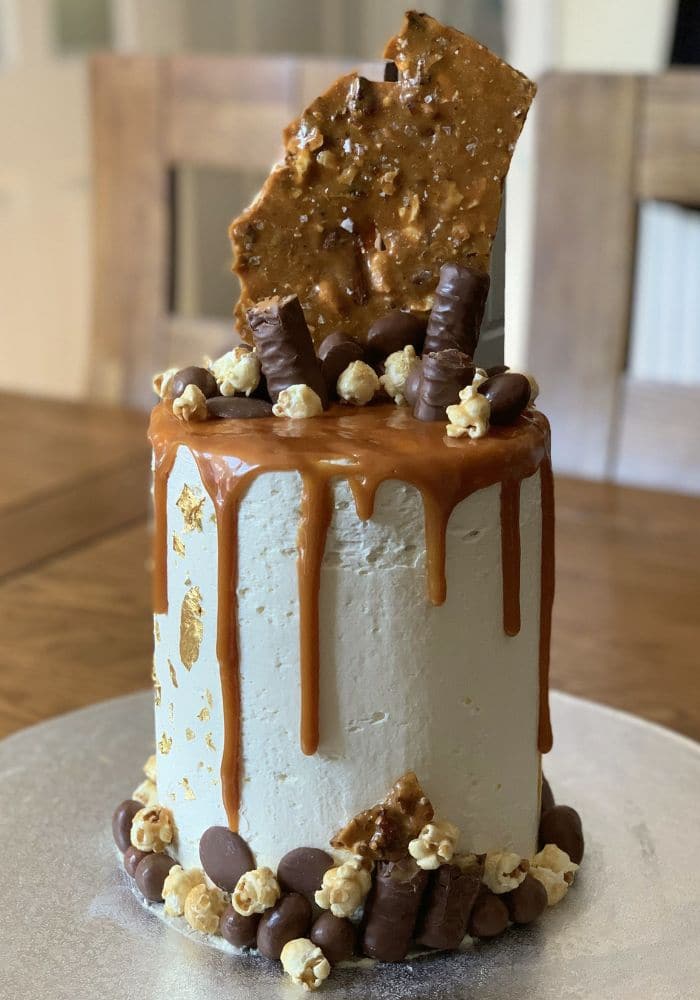 Buttercream cake with gold leaf, caramel drip, popcorn and a honeycomb shard