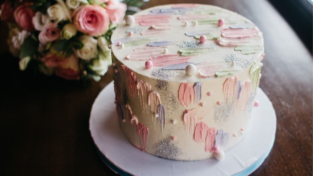 Pastel palette-knife painted cake with sugar pearls, styled with fresh roses