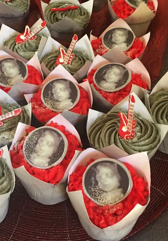 Red and green cupcakes topped with edible photo prints and guitar picks