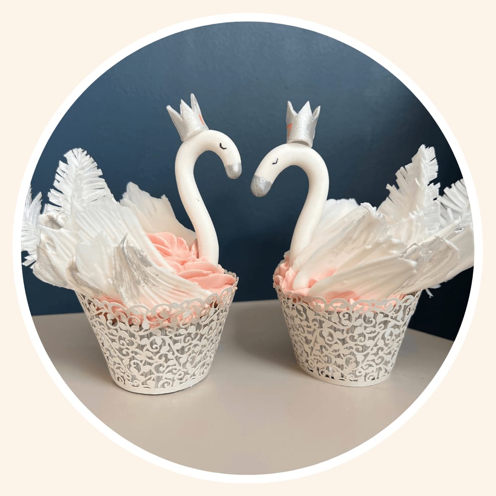 Two swan cupcakes facing each other to form a heart shape