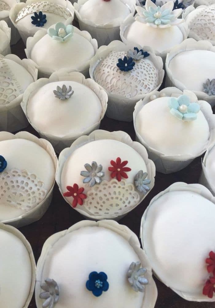 Elegant cupcakes topped with white and grey fondant and small sugar flowers